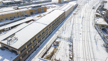 Fototapeta premium Aerial view of railroad section covered by snow. The tracks and rails are submerged by snow falling in Rome during the cold winter. The movement of metropolitan trains is blocked.