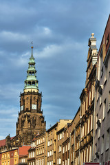 Houses and a gothic church tower with a clock in the city of Swidnica.