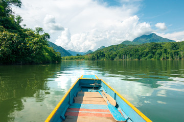 Obraz premium Travelling journey south down the remote Nam Ou river in Laos, in a colorful longboat.