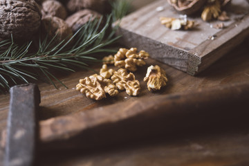 Cracked walnuts with hammer on the board
