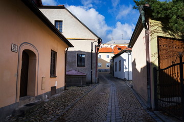 Fototapeta na wymiar Covered old stone fountain on beautiful cobbled street of historic town Tabor, South Bohemia, Czech Republic, sunny day