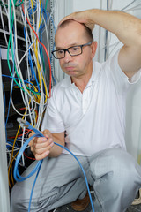 Confused man looking at cables