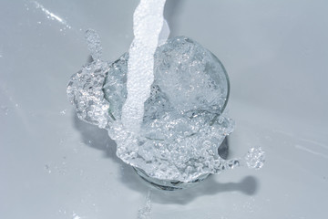 Wasser spritzt aus Glas