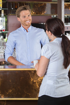 male barista flirting with female client at counter