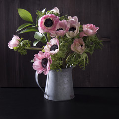 the Wedding bouquet of anemones with Ruscus in a jug on a black background