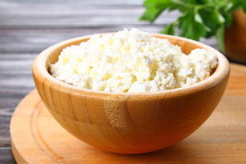 Home cottage cheese in a bowl on a wooden table.