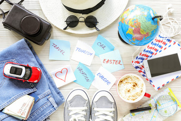 Traveler's accessories and items, stickers with notes on white wooden background, planning travel to Europe by car on Easter holiday concept.