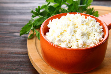 Home cottage cheese in a bowl on a wooden table.