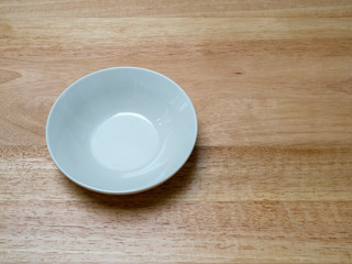 Angled shot of porcelain bowl with on chopping block