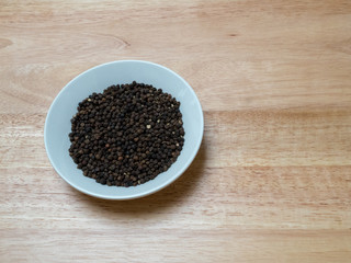 Angled shot of peppercorn in a porcelain bowl