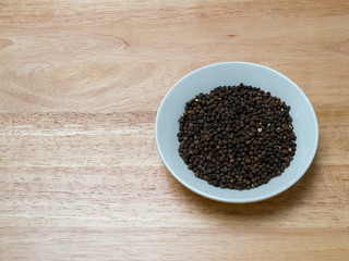 Angled shot of peppercorn in a porcelain bowl