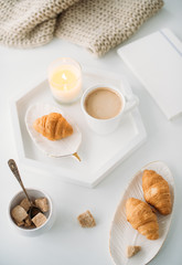Obraz na płótnie Canvas Cozy home breakfast, warm blanket, coffee and croissant on white