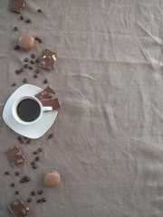 French macaroons, chocolate with a cup of black coffee, on a white background