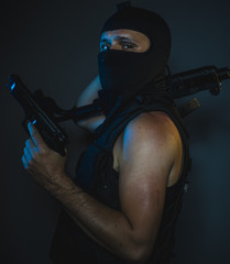 Mafia hit man, armed and dangerous man with balaclava and bulletproof vest, concept killer contract