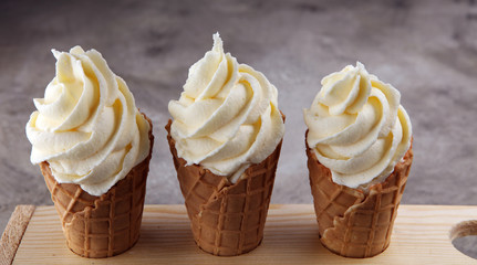 Vanilla frozen yogurt or soft ice cream in waffle cone.