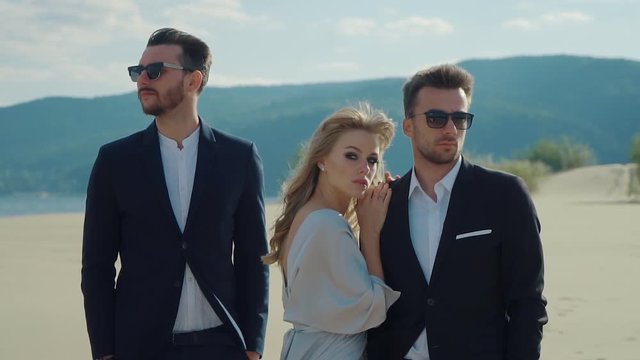 Pretty woman is leaning on a shoulder of man. Second man is discarded by her, love and jealousy between three people