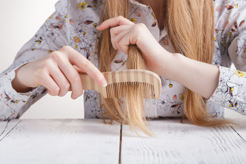 Obraz premium Woman with a comb in her hands problem hair