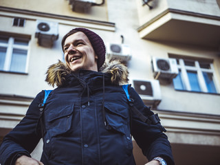 Obraz premium portrait of young smiling man walking in the europe streets with backback