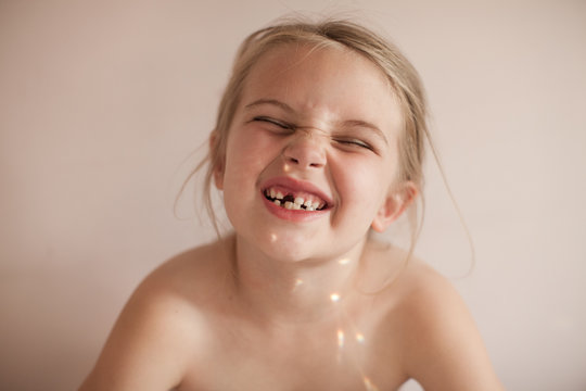 Cute young Girl With Snaggletooth Smile (Missing Front Tooth)  and Light reflecting on her skin from a prism