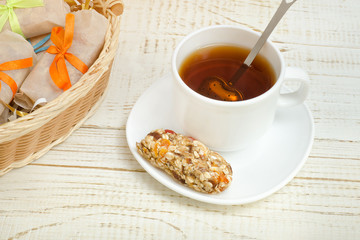 Cup of tea and a bar of muesli. Wicker basket in the background