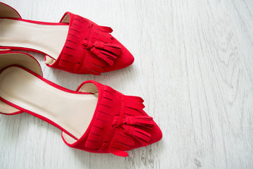 Red open shoes on a light wooden background. Top view