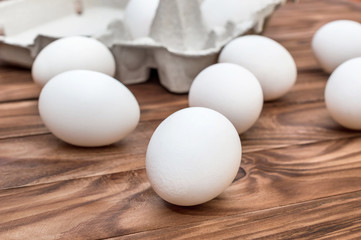 Raw eggs with carton container for eggs on the table.