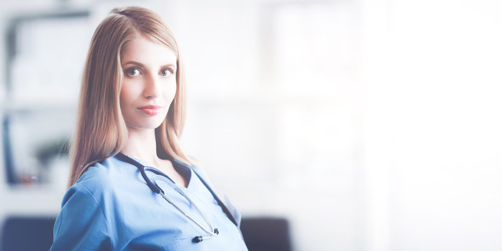 Doctor woman is standing in the near window