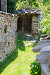 Narrow street covered with grass between old stone walls