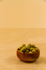 Bowl of wasabi covered peanuts.