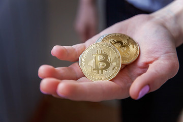 Cryptocurrency golden bitcoin coin in woman hand. Electronic virtual money for web banking and international network payment. Symbol of crypto currency
