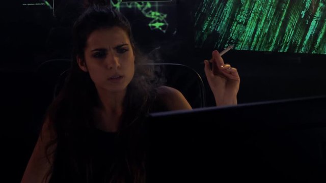 Two hackers working in darkness and smoke medium shot