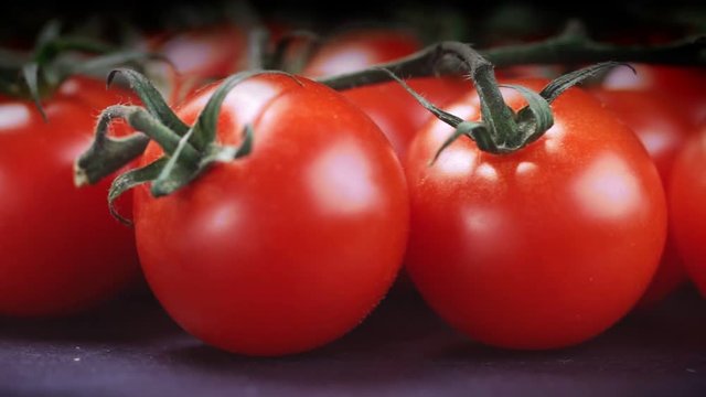 Ripe cherry tomatoes closeup on black background