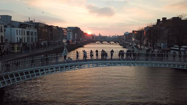 silhouette of unrecognizible people crossing the Ha Penny bridge in Dublin