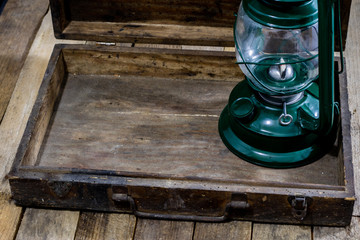 Fototapeta premium Oil lamp in an old wooden case. Old accessories set on a wooden table.