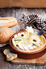 Delicious  hot baked camembert with sultanas on wooden table