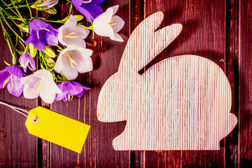 Happy Easter mockup. wooden rabbit with spring flowers and sale label or tag with copy space. easter mockup template. easter sale, greeting and celebration card concept. Postcard, cover and border