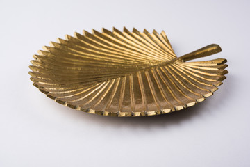 Empty golden ceramic designer plate in leaf shape , isolated on white background
