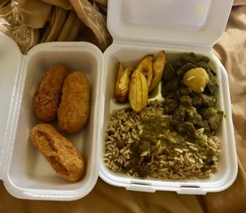 Take away box of delicious Jamaican food: Curry Goat with Rice & Peas and gravy, sweet plantain and a side of festival