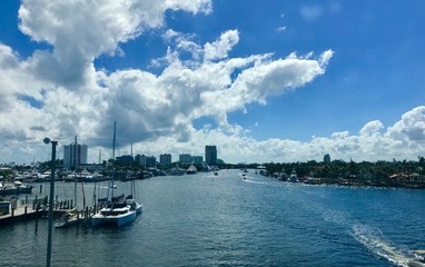 Fototapeta na wymiar Impressive Las Olas Boulevard with clear water, sailing boats, luxurious houses and a beautiful blue sky with white clouds in Fort Lauderdale - Florida (USA)