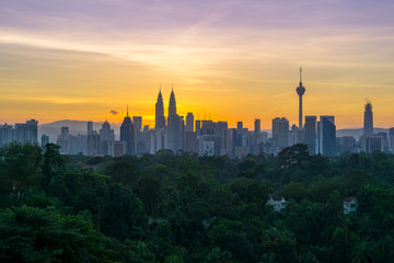 Fototapeta na wymiar Majestic sunrise over Petronas Twin Towers and surrounded buildings in downtown Kuala Lumpur, Malaysia