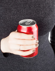 Female holding a closed can of soda