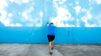 Attractive young man stretching on the track before running