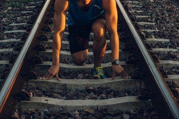 Close up the runner start from run on railroad tracks with dramatic tone, Sunset running in the evening