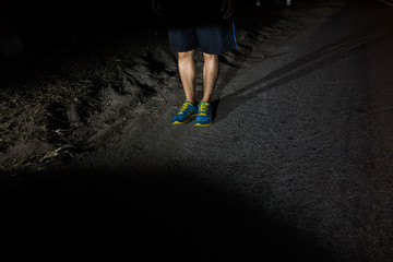 Close up  runner legs on the highway road in the midnight, Sport concept.