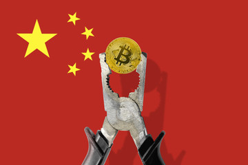 BITCOIN coin being squeezed in vice on the China flag background; concept of cryptocurrency bitcoin under pressure. Prohibition of cryptocurrencies, regulations, restrictions or security