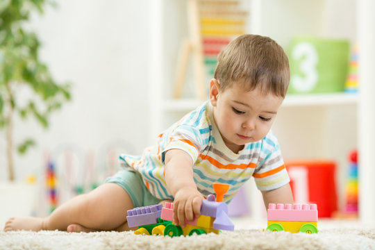 Toddler playing with toys on a white carpet at home