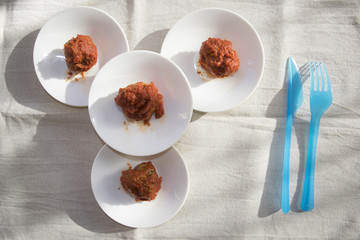four white saucer with meatballs in tomato sauce