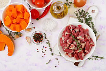 Ingredients for cooking chicken hearts with pumpkin and tomatoes in tomato sauce. The garnish is served with boiled rice. Flat lay. Top view.
