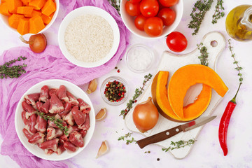 Ingredients for cooking chicken hearts with pumpkin and tomatoes in tomato sauce. The garnish is served with boiled rice. Flat lay. Top view.
