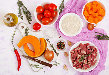 Ingredients for cooking chicken hearts with pumpkin and tomatoes in tomato sauce. The garnish is served with boiled rice. Flat lay. Top view.